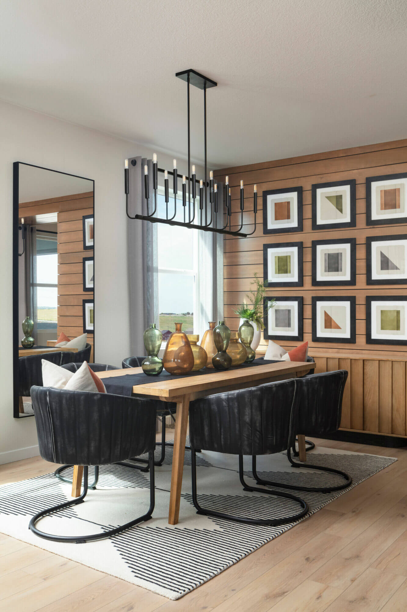 A dining room with a wood paneled wall.