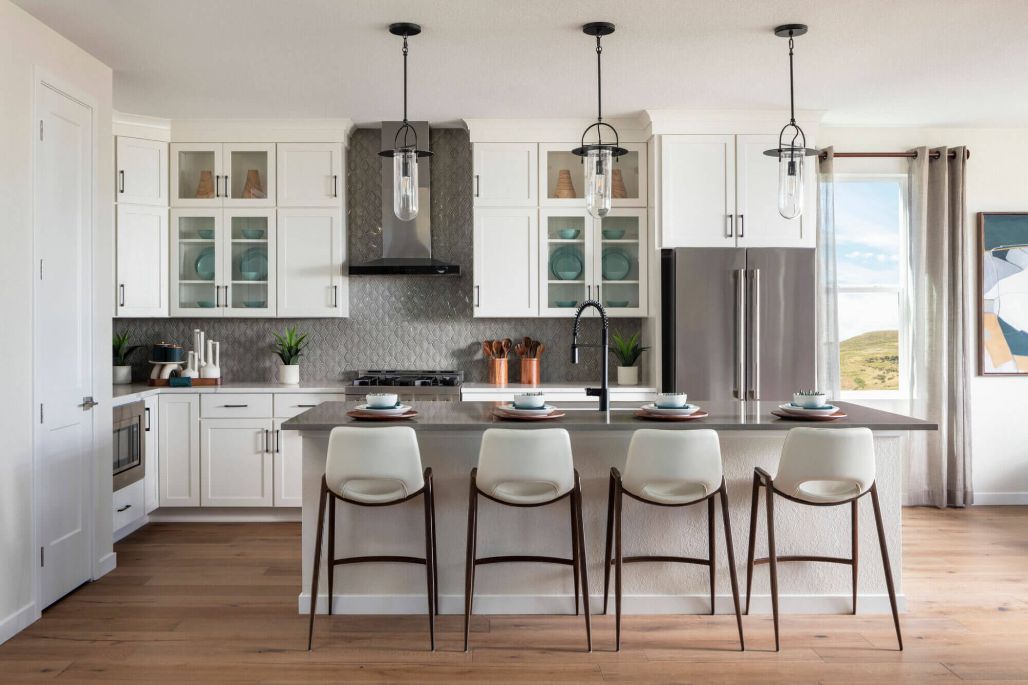 A white kitchen with a center island and bar stools.