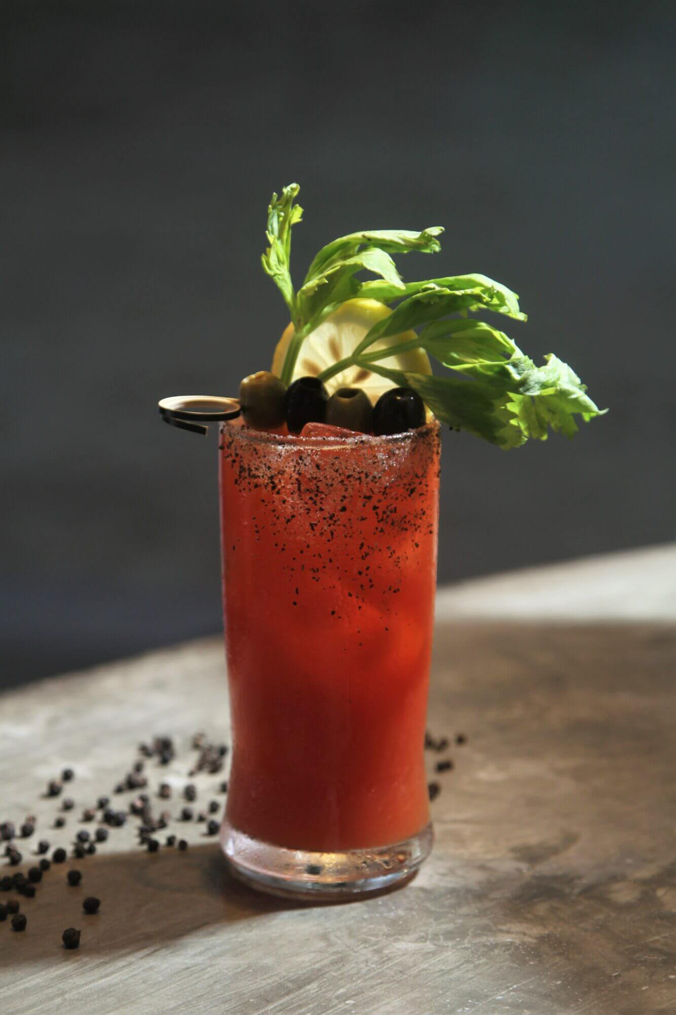 A bloody mary with black olives and basil.