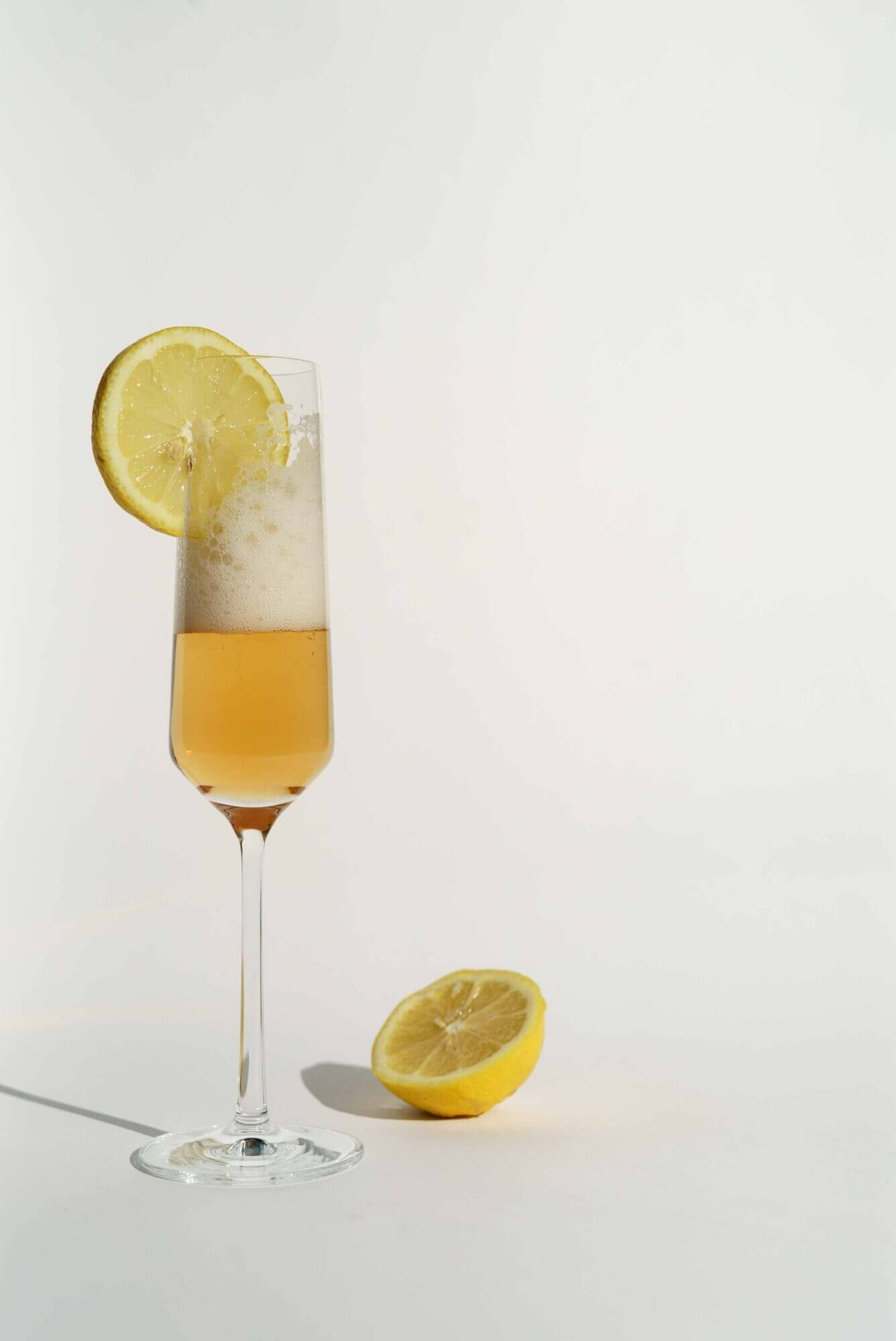 A glass of lemonade with a slice of lemon.