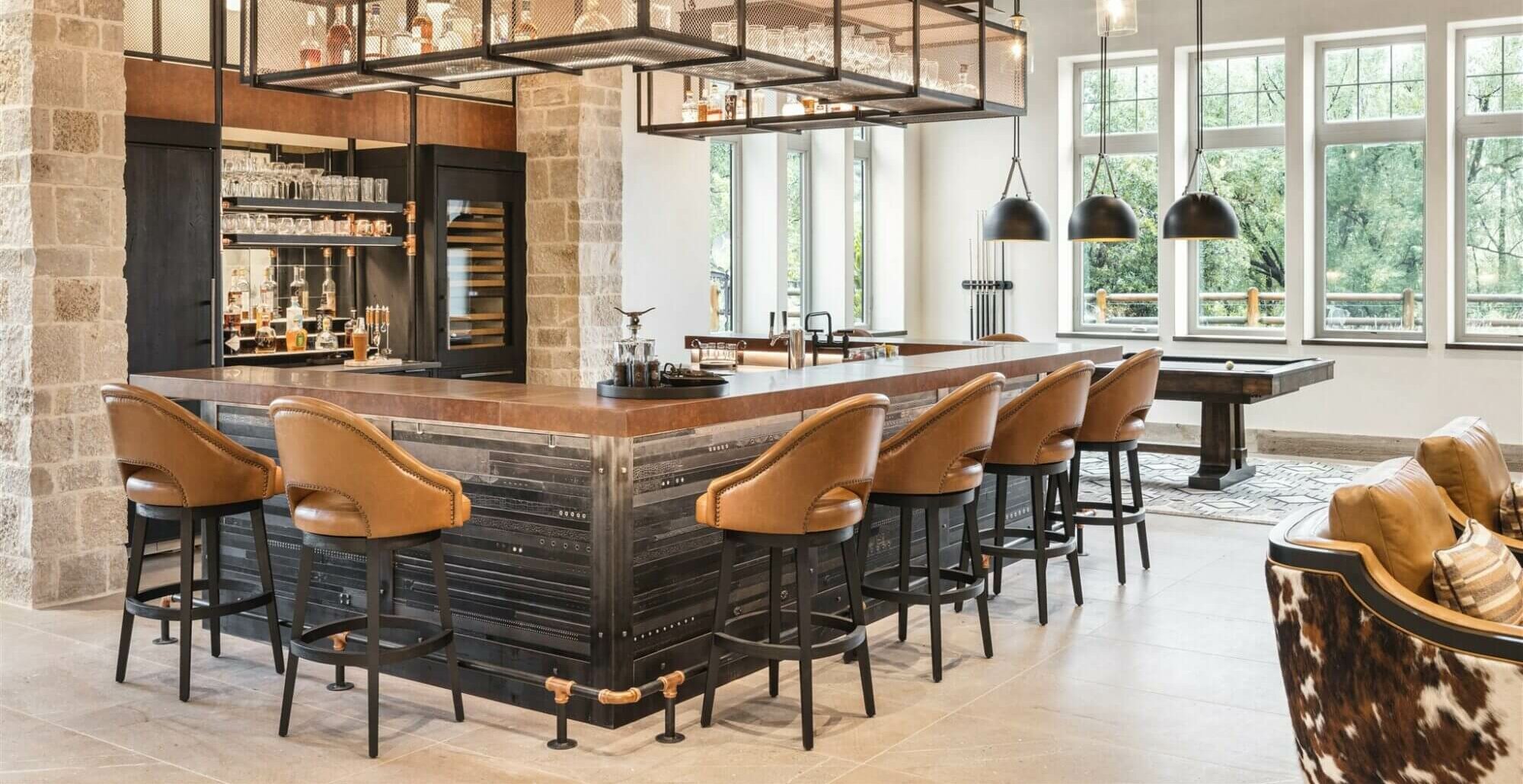 A rustic kitchen with a bar and cowhide stools.
