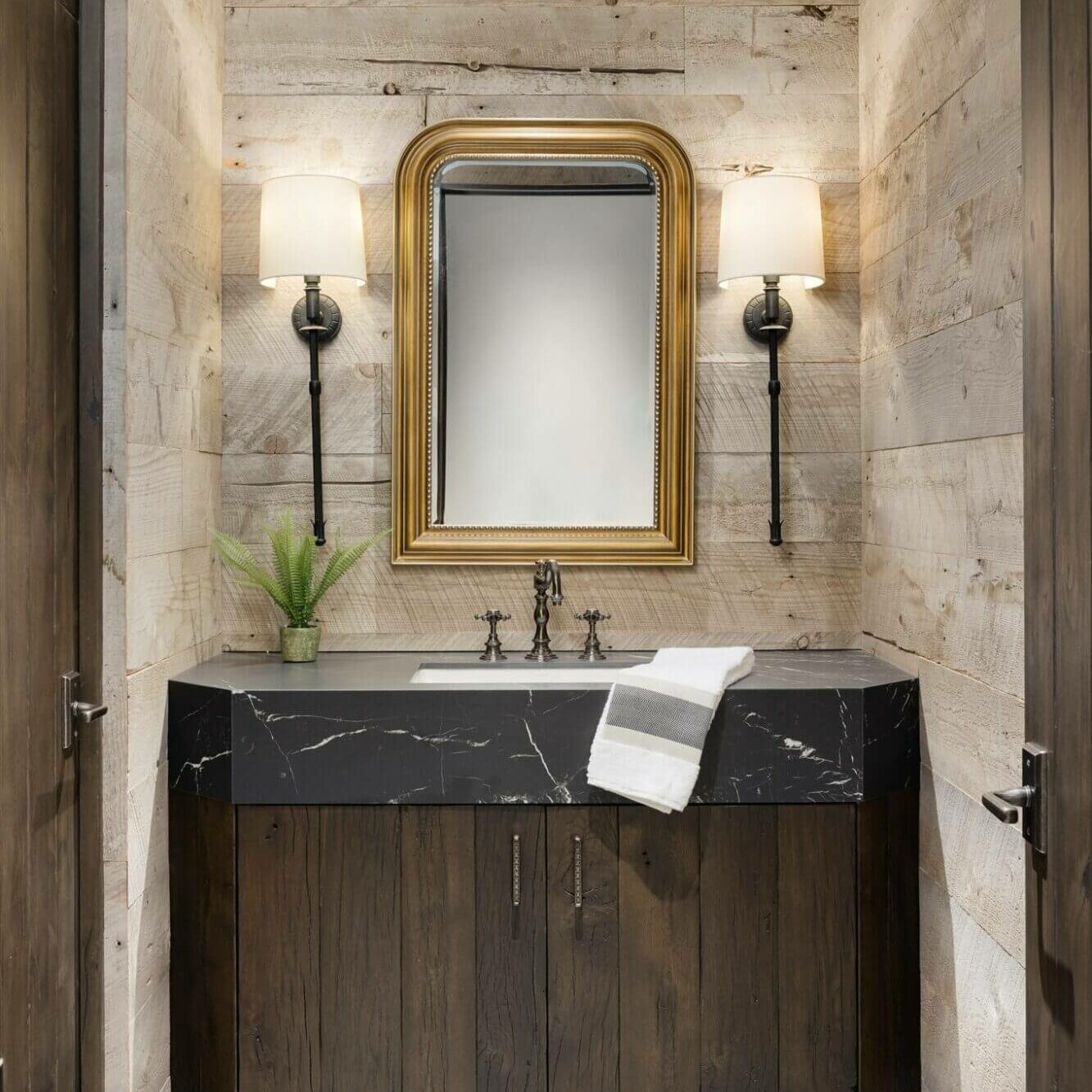 A bathroom with marble counter tops and a large mirror.