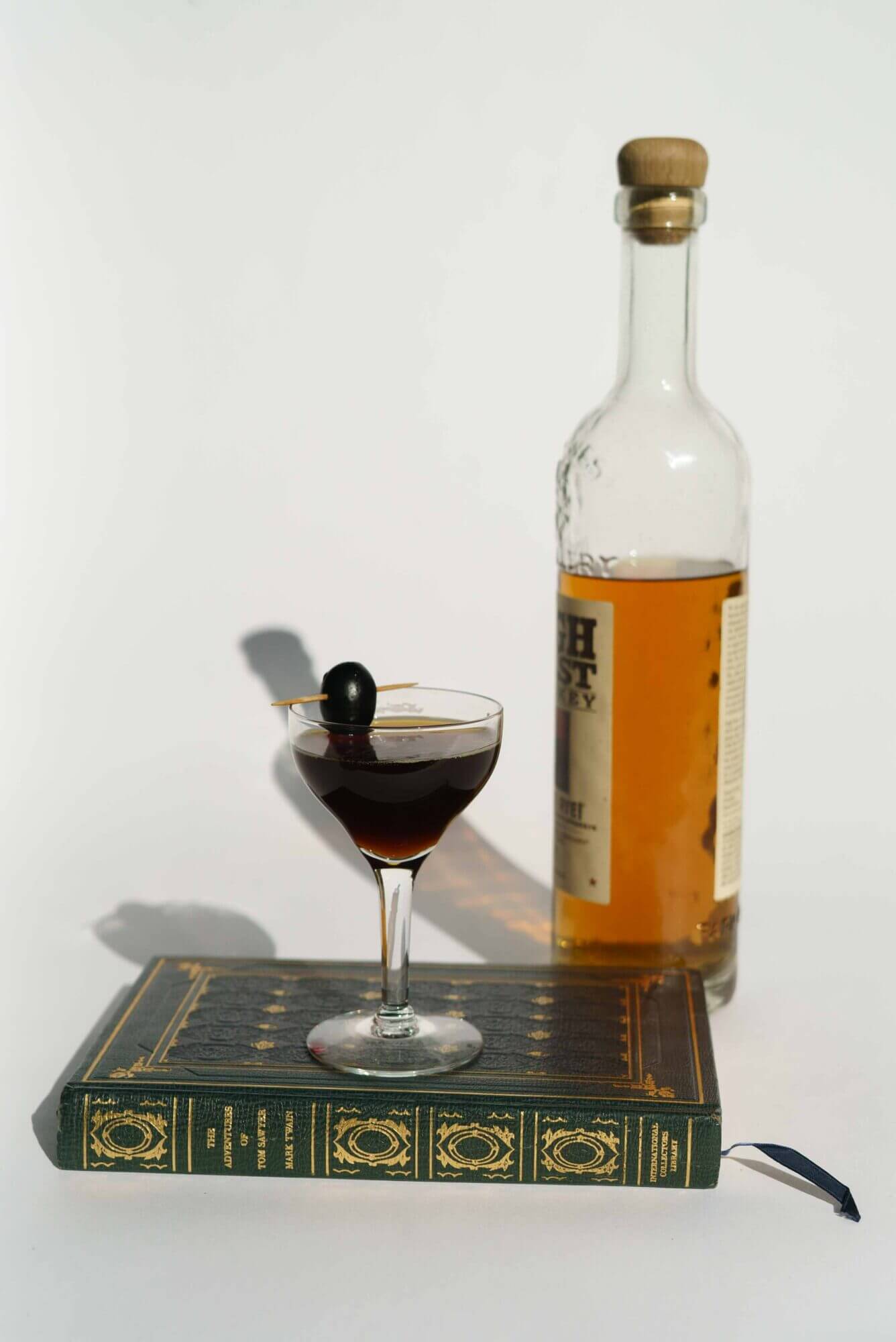 A bottle of bourbon sits on top of a book.