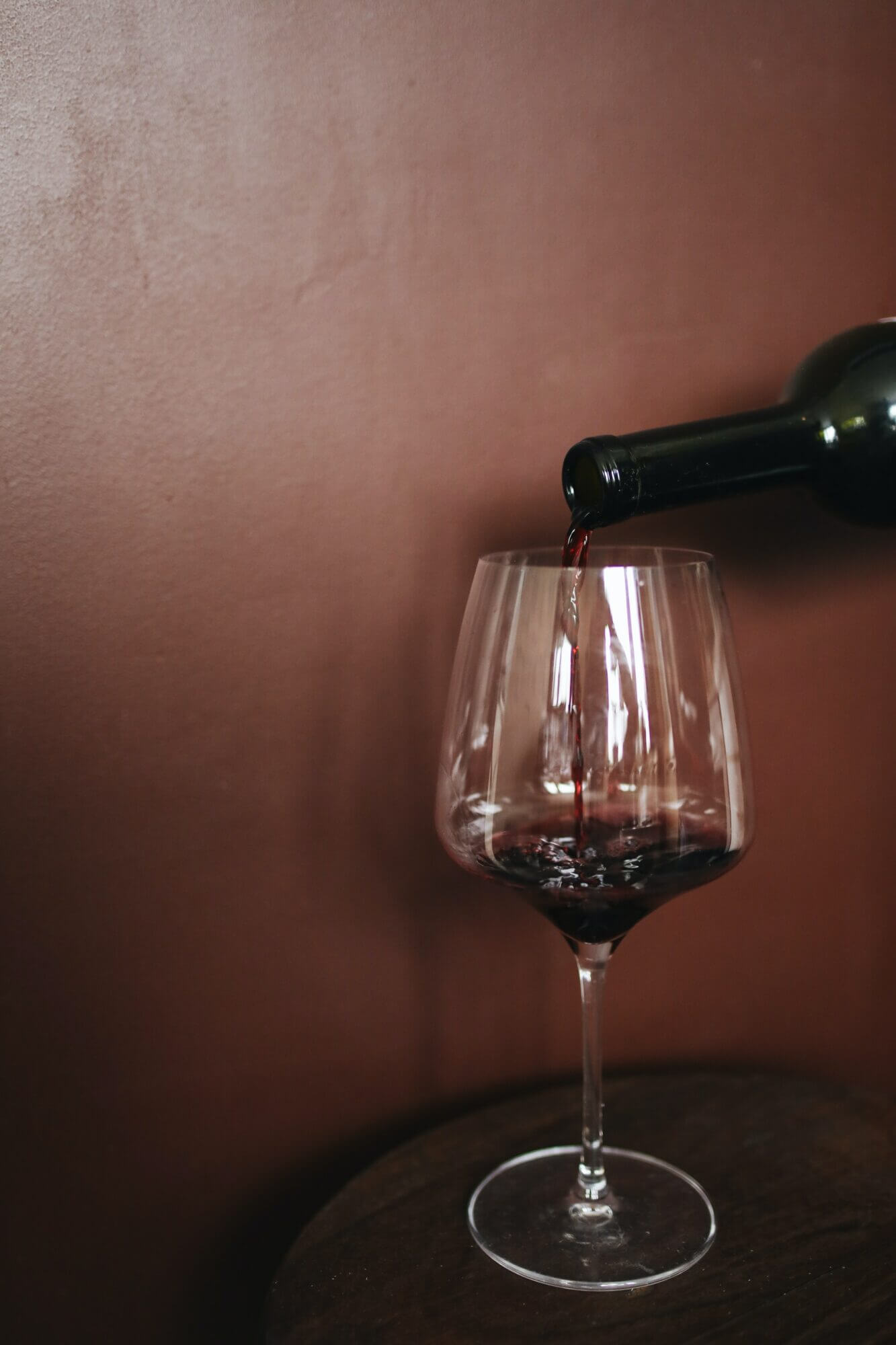 A glass of red wine is being poured into a glass.