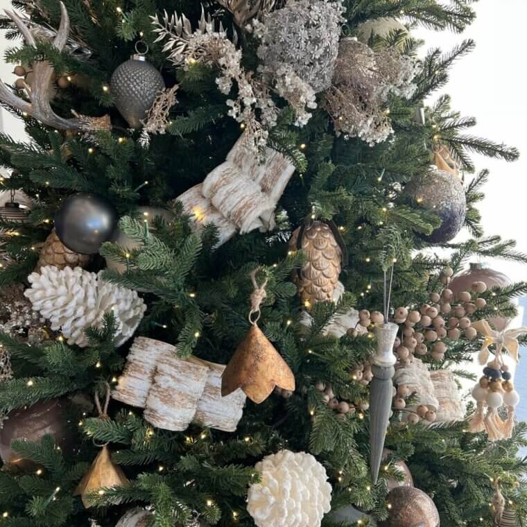 A christmas tree decorated with white and gray ornaments.
