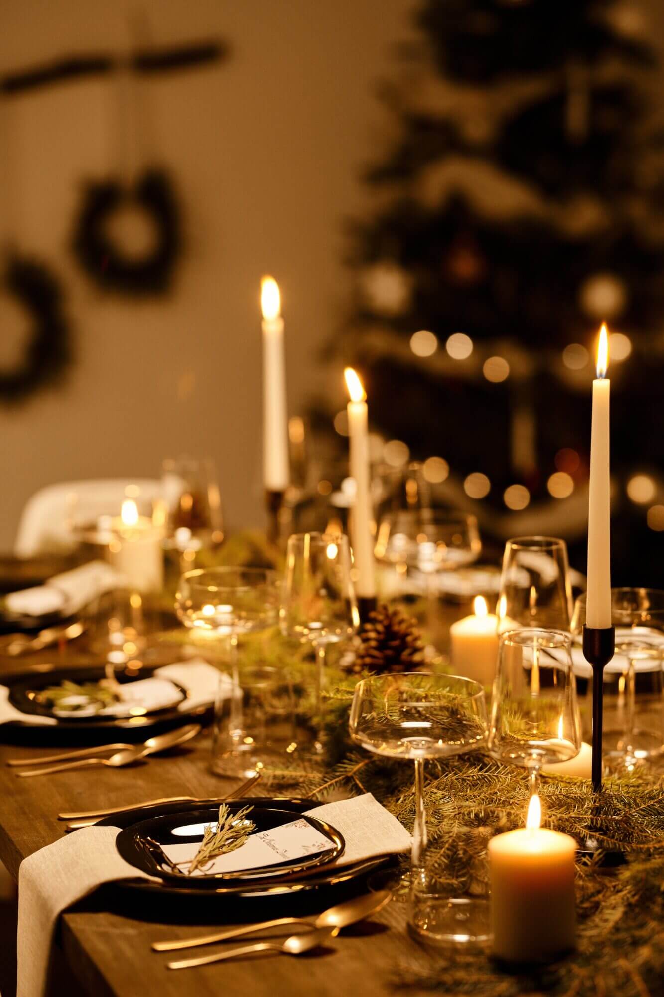 A christmas table setting with candles and place settings.