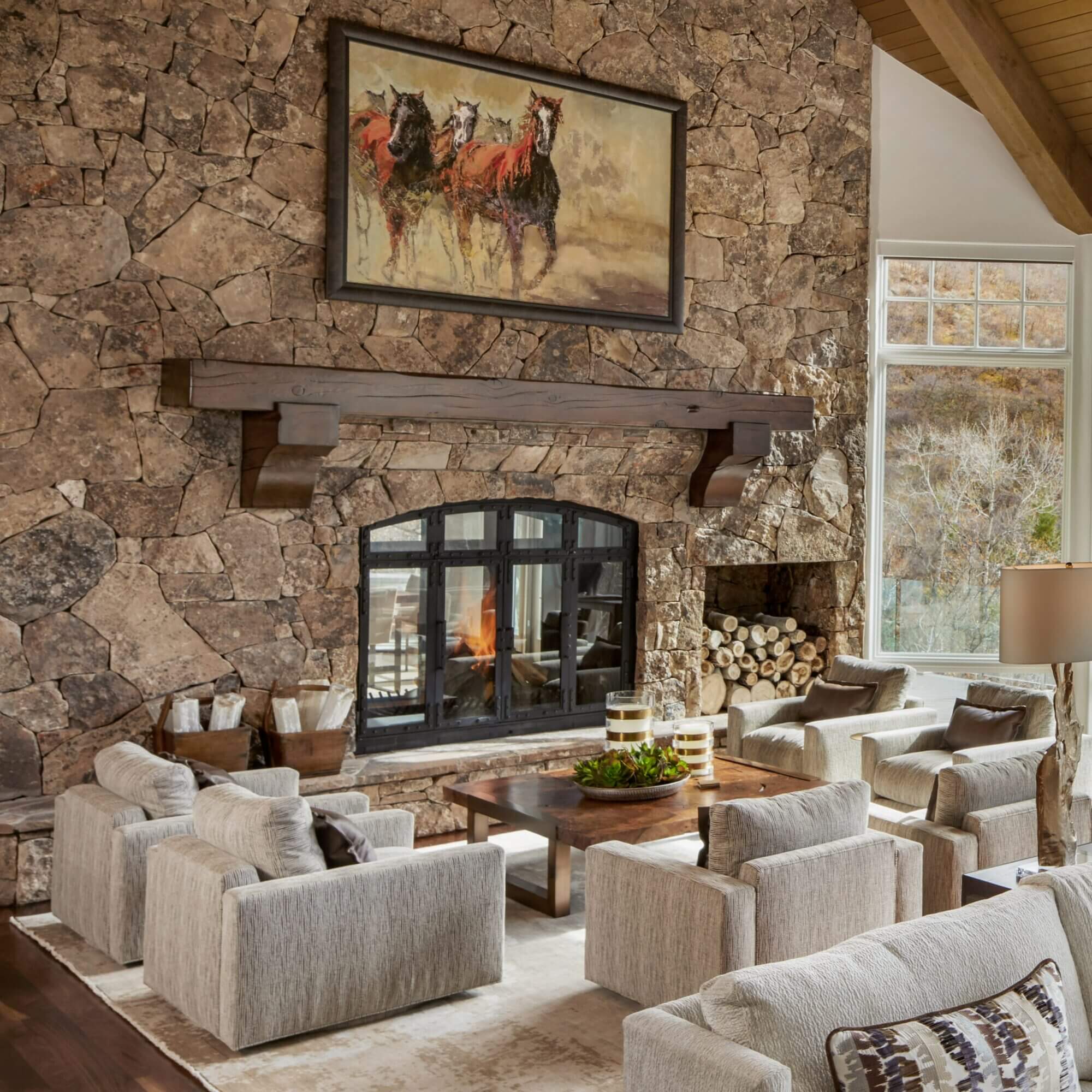 A living room with a stone fireplace and couches.