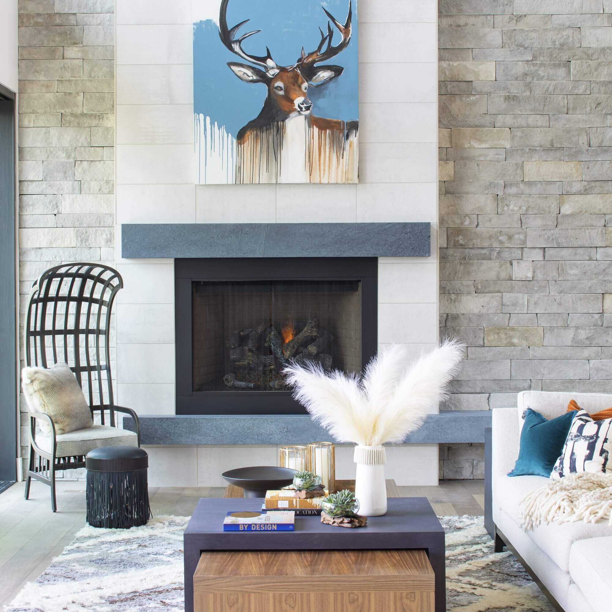 A living room with a fireplace and a deer on the wall.