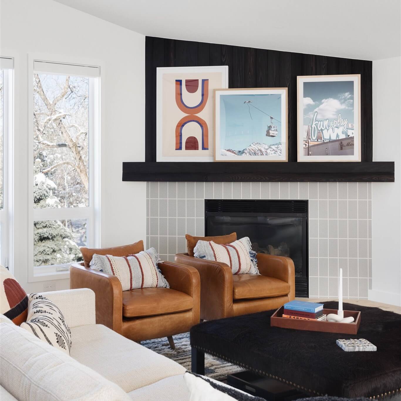 A living room with a fireplace and framed pictures.