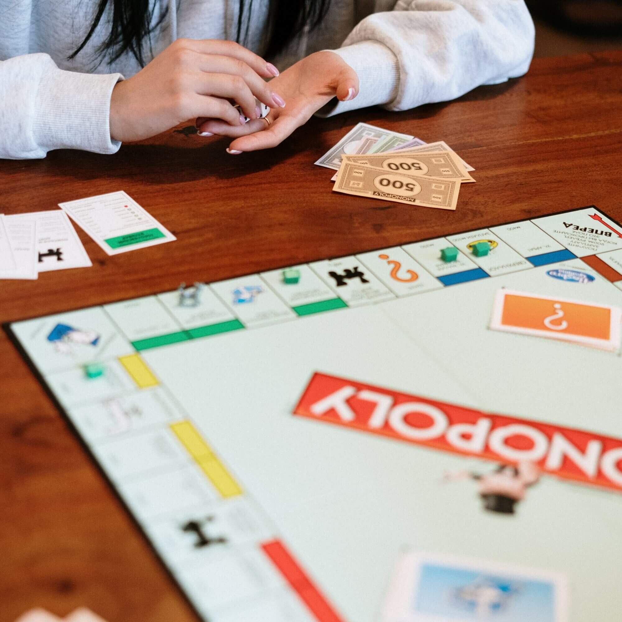 A woman playing monopoly on a table.